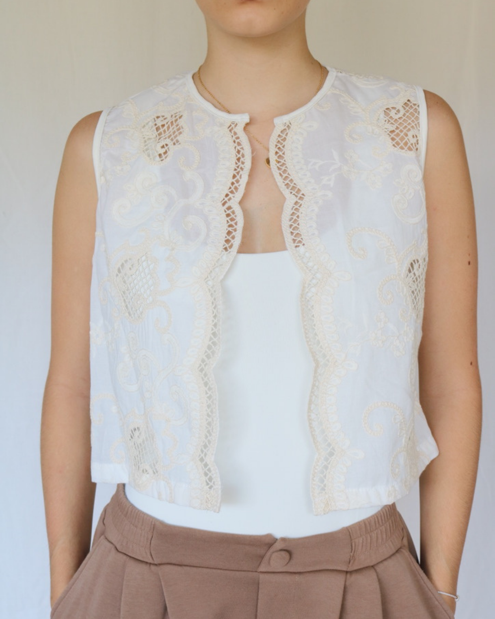 Chaleco básico confeccionado en algodón, con delicados detalles bordados que aportan un toque distintivo.