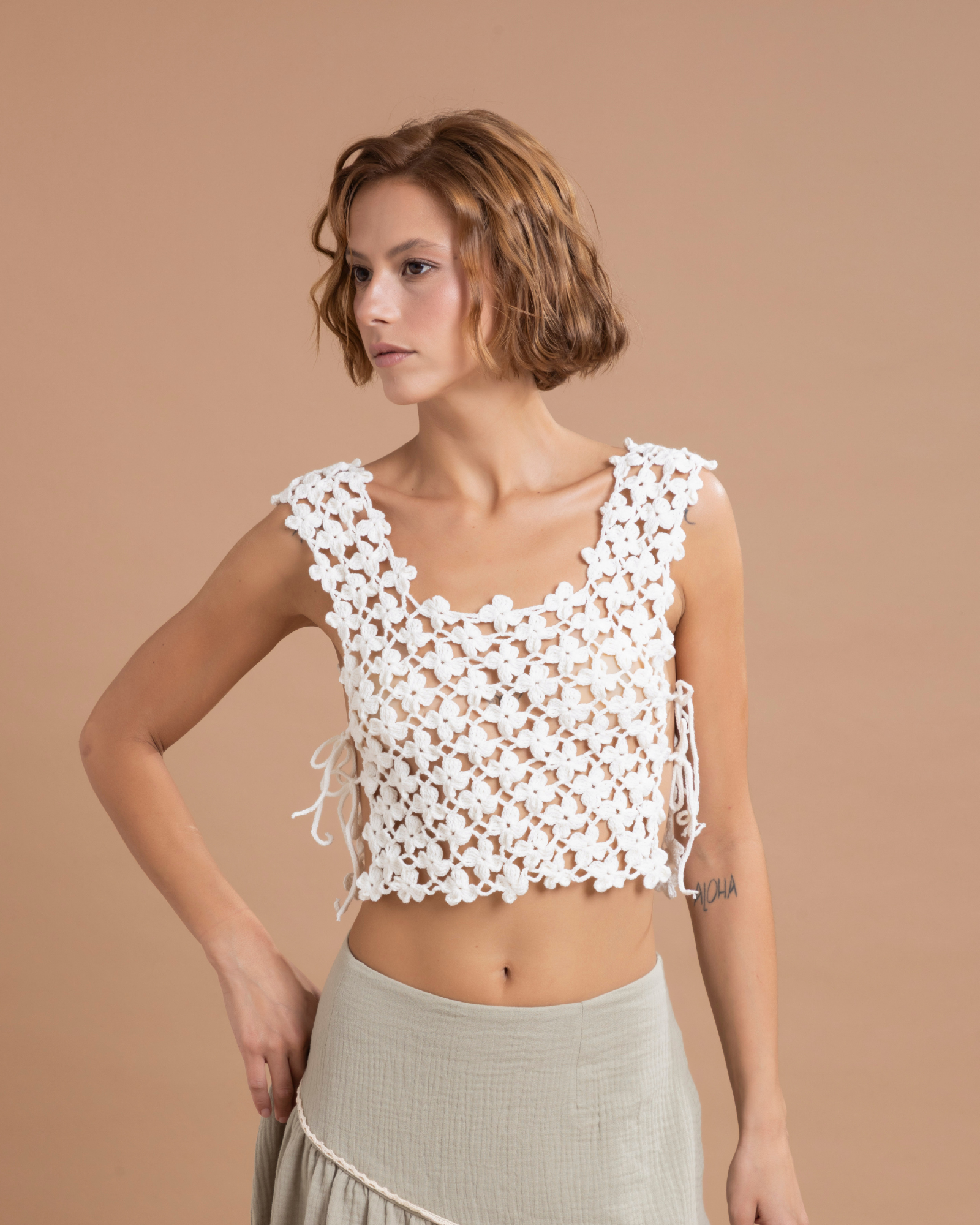 Chaleco estilo peto, 100% tejido a mano en algodón, con un delicado patrón de flores en crochet. Se ajusta cómodamente a los costados.