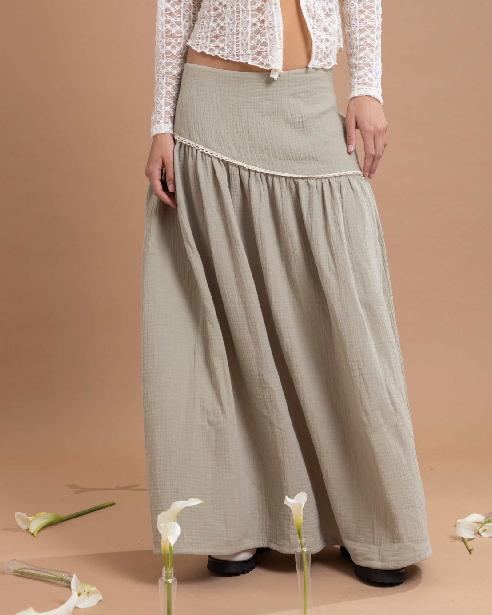 Falda larga confeccionada en algodón, con un detalle asimétrico en la parte superior que aporta movimiento y estilo. Cuenta con cierre invisible lateral para un ajuste discreto y cómodo