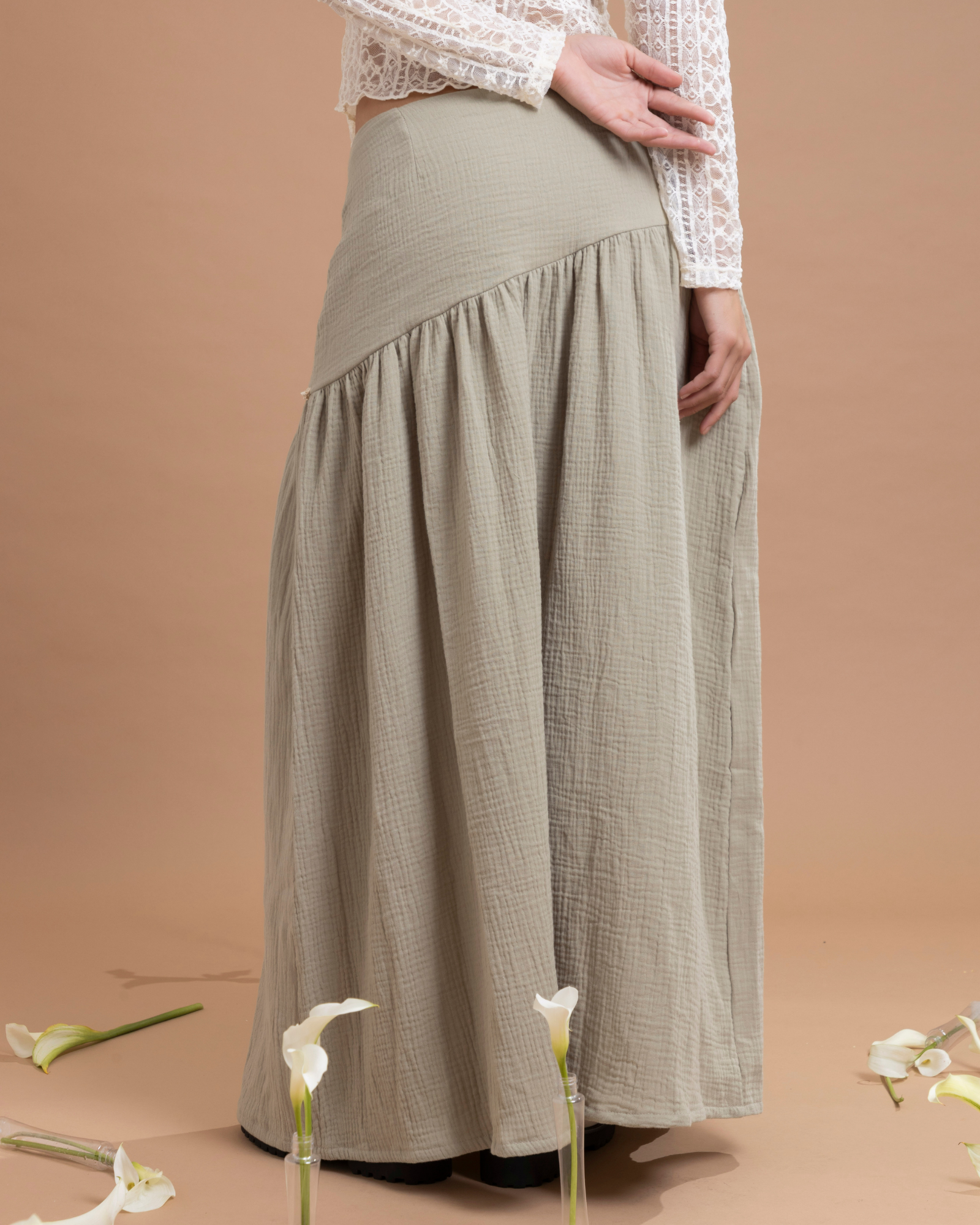 Falda larga confeccionada en algodón, con un detalle asimétrico en la parte superior que aporta movimiento y estilo. Cuenta con cierre invisible lateral para un ajuste discreto y cómodo