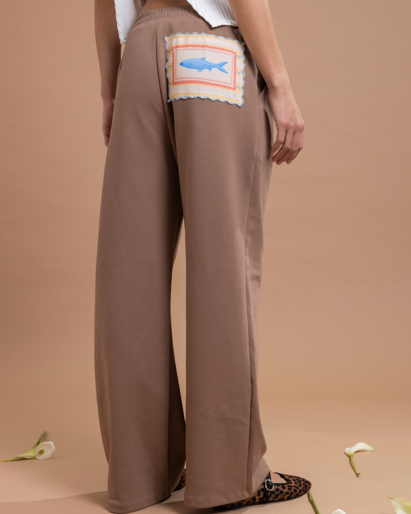 Pantalón con pinzas confeccionado en tela tipo sudadera, que combina comodidad y una apariencia elegante. En la parte posterior cuenta con una ilustración exclusiva de la marca.&nbsp;