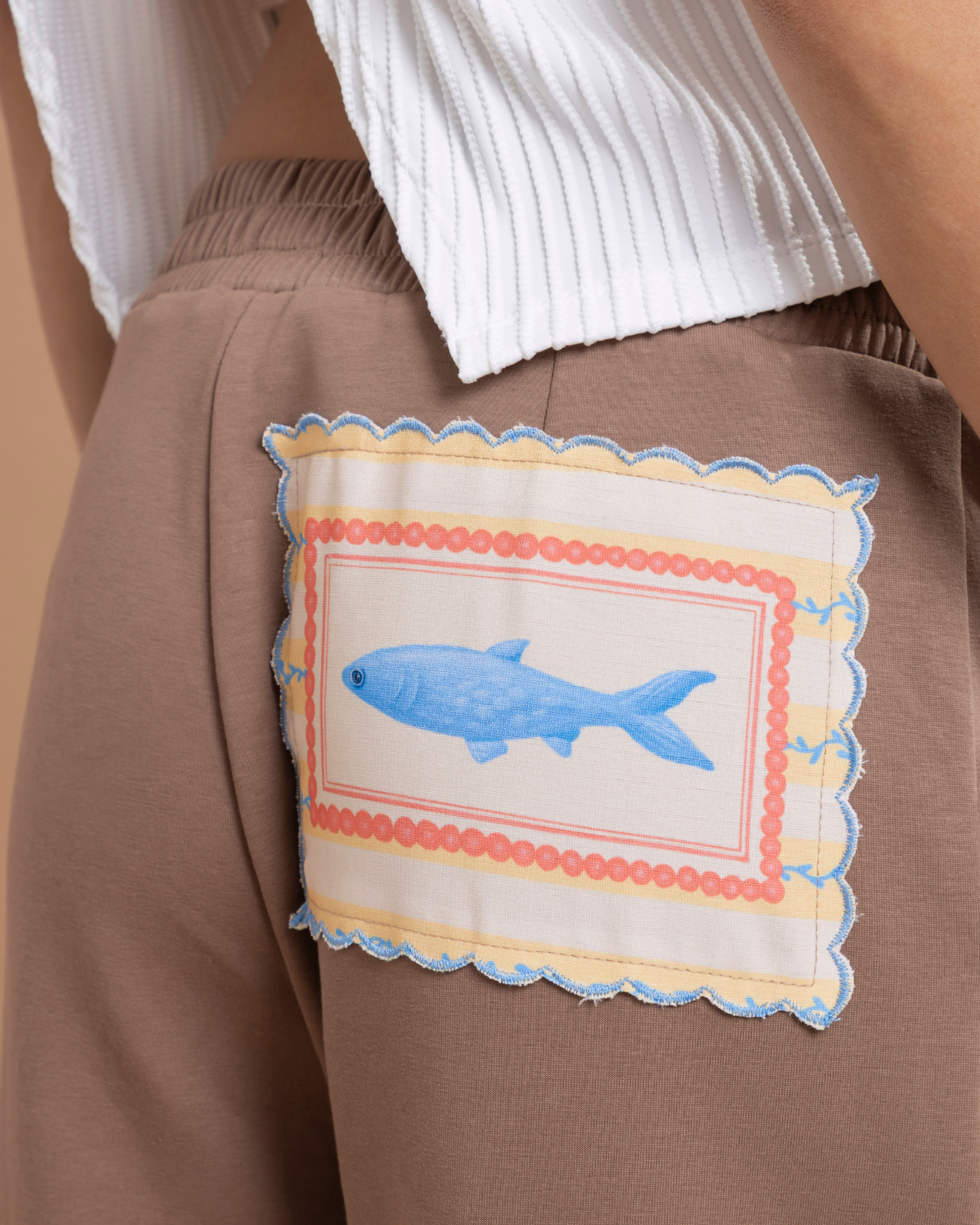 Pantalón con pinzas confeccionado en tela tipo sudadera, que combina comodidad y una apariencia elegante. En la parte posterior cuenta con una ilustración exclusiva de la marca.&nbsp;