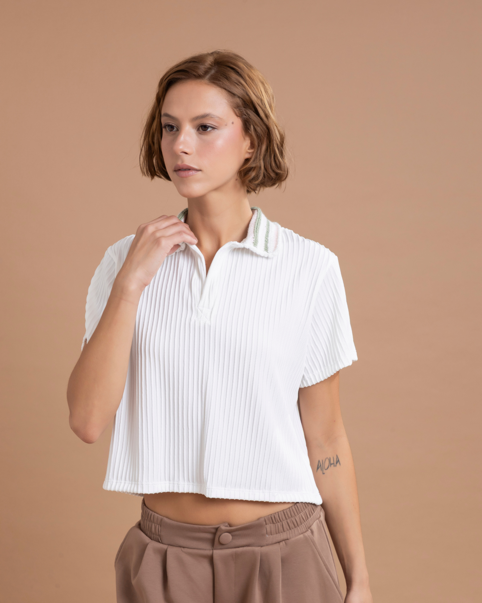 Camisa tipo polo confeccionada en lycra con textura, de horma oversized. Su cuello, tejido 100% a mano en crochet. Con abertura en la parte posterior de la prenda.