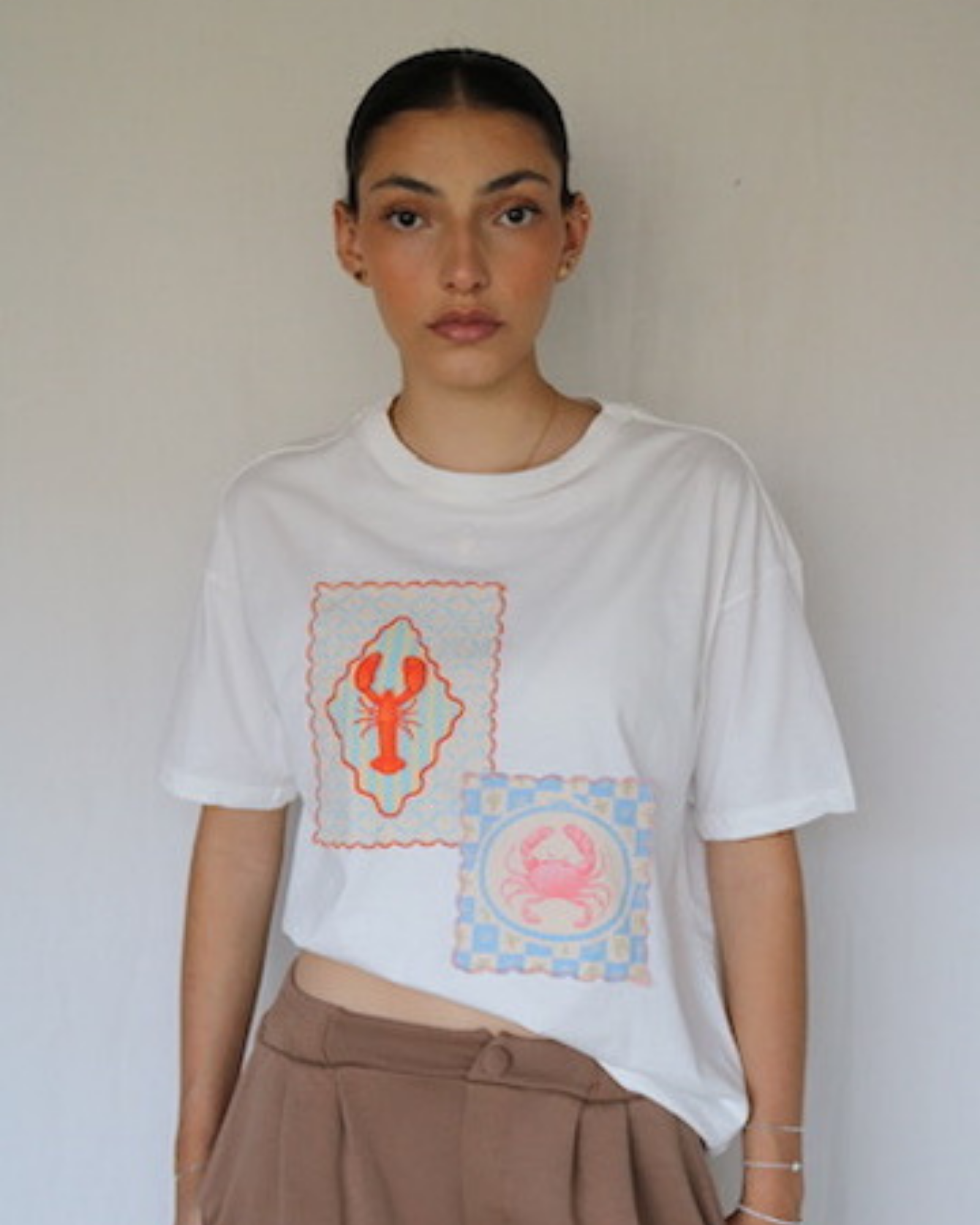 Camiseta oversized confeccionada en algodón peruano, con ilustraciones exclusivas de la marca que reflejan su identidad artística y distintiva.