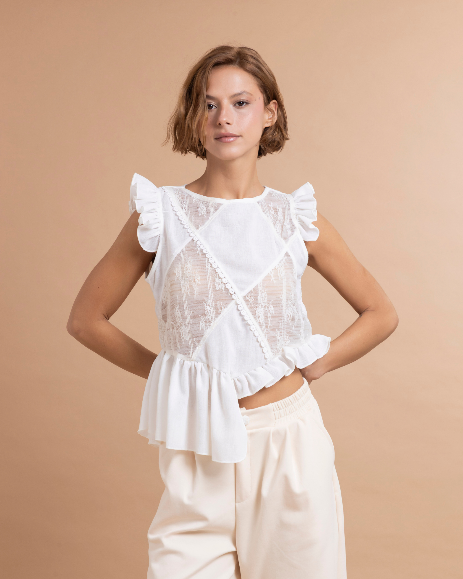 Top asimétrico confeccionado en tela de algodón. La parte delantera está elaborada en patchwork a partir de excedentes textiles, lo que aporta textura y contraste al diseño. Presenta boleros inferiores con largos diferentes aportando un diseño asimétrico que añaden movimiento y volumen a la prenda.