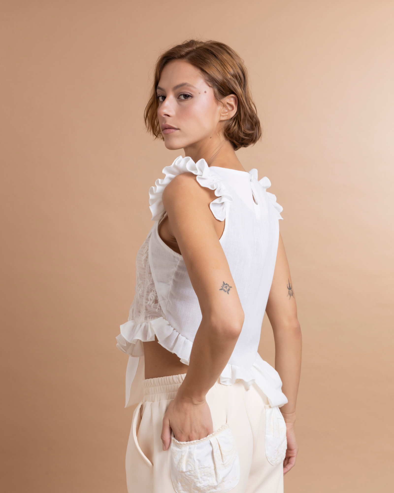 Top asimétrico confeccionado en tela de algodón. La parte delantera está elaborada en patchwork a partir de excedentes textiles, lo que aporta textura y contraste al diseño. Presenta boleros inferiores con largos diferentes aportando un diseño asimétrico que añaden movimiento y volumen a la prenda.