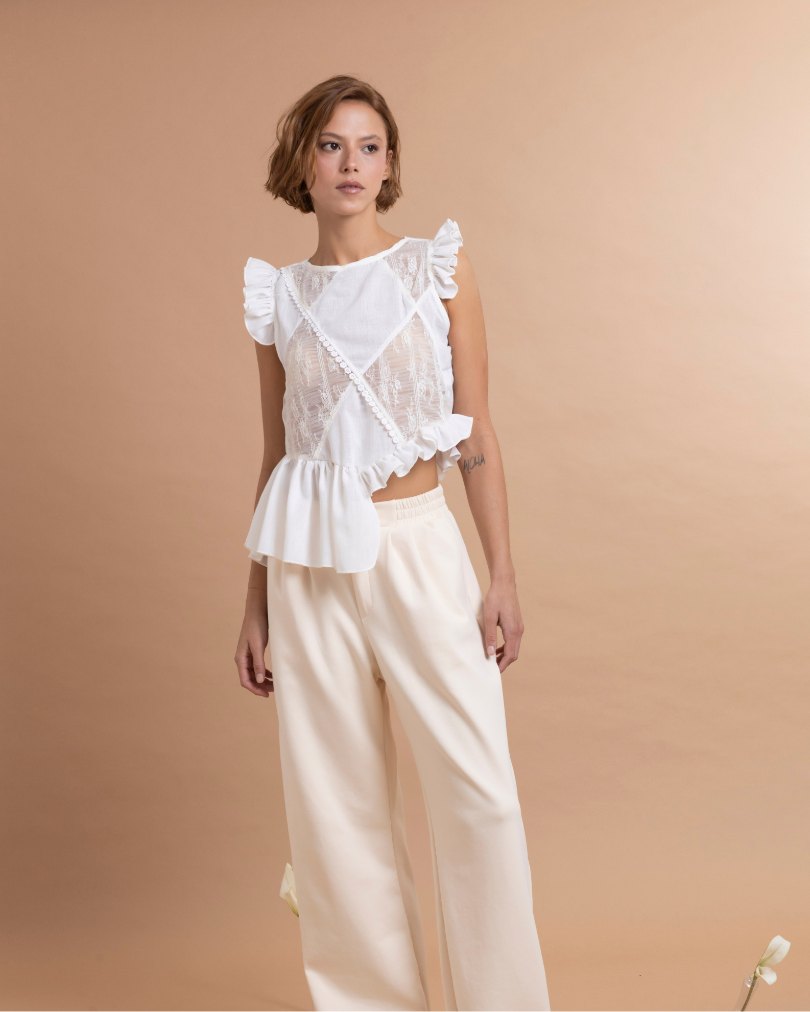 Top asimétrico confeccionado en tela de algodón. La parte delantera está elaborada en patchwork a partir de excedentes textiles, lo que aporta textura y contraste al diseño. Presenta boleros inferiores con largos diferentes aportando un diseño asimétrico que añaden movimiento y volumen a la prenda.