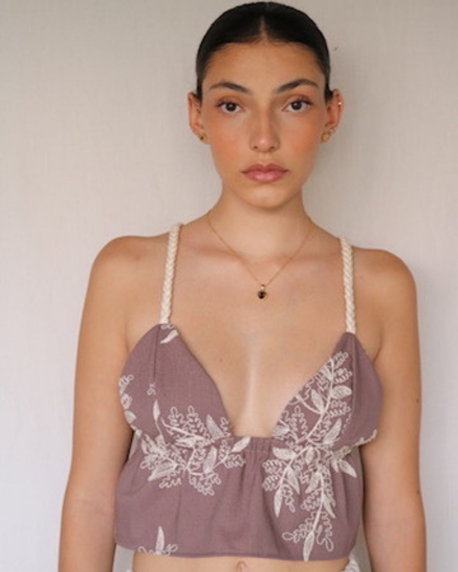 Top confeccionado en lino con textura bordada, con elástico en la parte posterior que permite un ajuste cómodo y versátil, adaptándose a tallas desde XS hasta M.